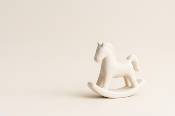 Minimal ceramic rocking horse figurine on a soft neutral background