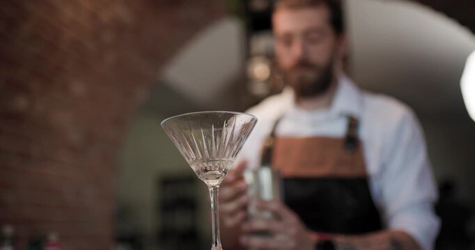 Crafting a cocktail in a busy bar as a skilled barman mixes a delicious drink during a lively evening shift