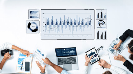 A modern meeting scene depicting professionals analyzing data and statistics on a table, showcasing collaborative efforts through technology and charts for business growth. Trope