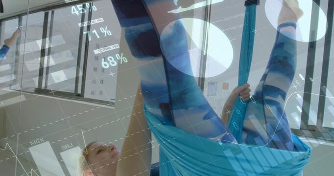 Woman grabbing sling, climbing and inverting, then returning to support, fitness HUD showing charts