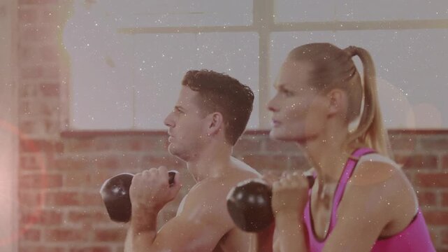 Man holding kettlebell woman joining syncing squats down or up for fitness lens-flare accenting moti