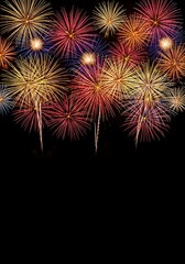 Fototapeta premium A vibrant display of multi-colored fireworks bursting across the top third of a black background, creating a festive border perfect for New Year's Eve cards, holiday announcements