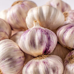 Close-up of garlic cloves partially peeled, revealing smooth surfaces and natural color. Ideal for recipe illustrations, kitchen visuals, wellness content, and organic ingredient concepts.