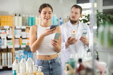 Fotobehang Ridders Young woman buyer scanning qr code for moisturizing cream with young man pharmacist in pharmacy  © JackF