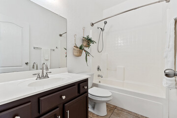 Fototapeta premium A welldesigned bathroom with a sink, toilet, bathtub, and mirror