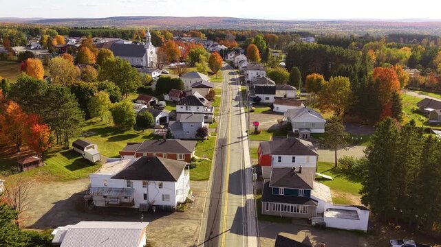 Aerial autumn view of the main street in Saint-Romain, Estrie, Quebec, Canada. Colorful fall foliage, small-town atmosphere, rural landscape and peaceful countryside setting.
