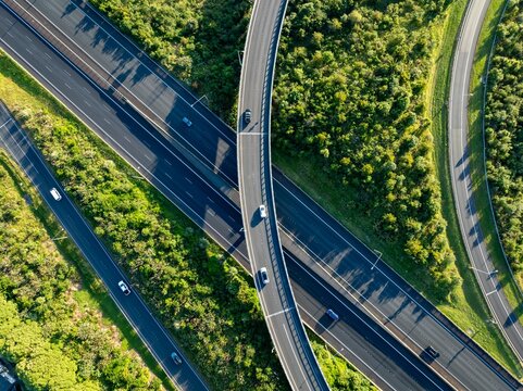 Fototapeta Aerial view of cars driving on a highway interchange in Manukau, Auckland, New Zealand. The photo shows the infrastructure and transportation system.