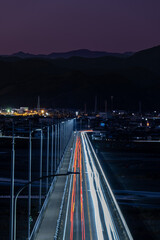 夜景と山並みが織り成す光跡の都市風景
