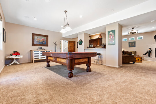 In the center of the room, there is a billiard pool table present