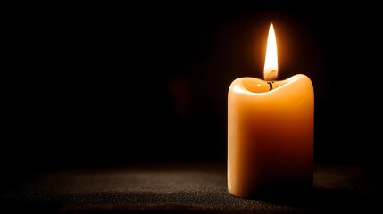 Illuminated wax cylinder burns brightly against a deep, dark background