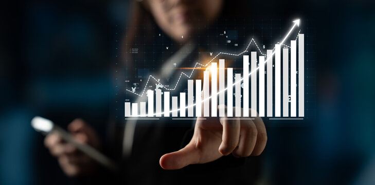 A businesswoman engages with a smartphone while analyzing a digital financial growth chart, showcasing progress and trends in a modern corporate environment. Impute - Powered by Adobe
