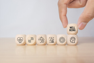 Employee wellbeing concept. Wooden blocks with physical, mental, emotional health icons. Creating employee benefits, satisfaction programs. Fostering positive work culture, employee engagement