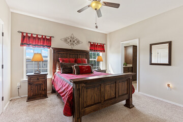 A cozy bedroom with a bed, nightstands, lamps, and ceiling fan