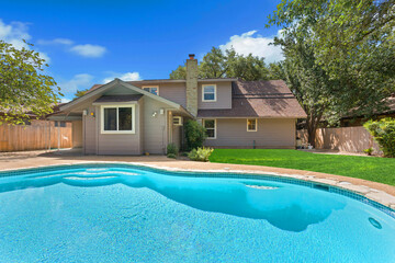 A beautiful house with a large swimming pool in front, creating charm