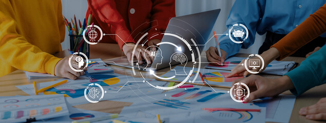 Diverse team members actively engage in strategic planning, utilizing technology and charts in a...