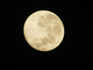 Detailed close-up view of a yellow waxing crescent moon with visible craters against a dark black sky