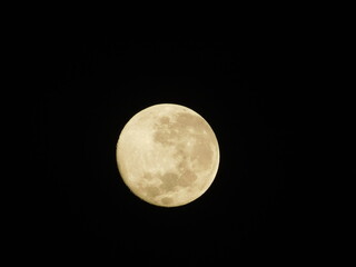 Detailed close-up view of a yellow waxing crescent moon with visible craters against a dark black sky