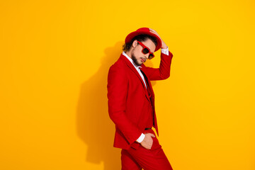 Funny bold red suit man with hat and sunglass strikes a stylish pose against a bright yellow background for a high energy fashion vibe