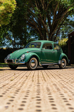Green Volkswagen Beetle front three quarter view, Classic 1300 model parked on pavement