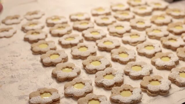 Closeup of aligned eggnog filled Christmas cookies in warm festive holiday baking scene