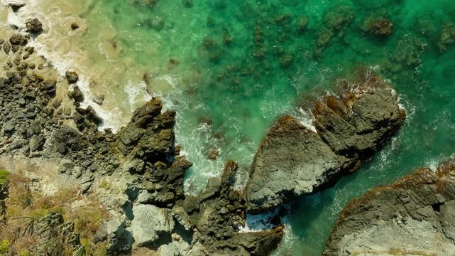 DRONE : TOP DOWN VIEW OF THE ROCKS AND THE BEACH OF IXTAPA AT NOON