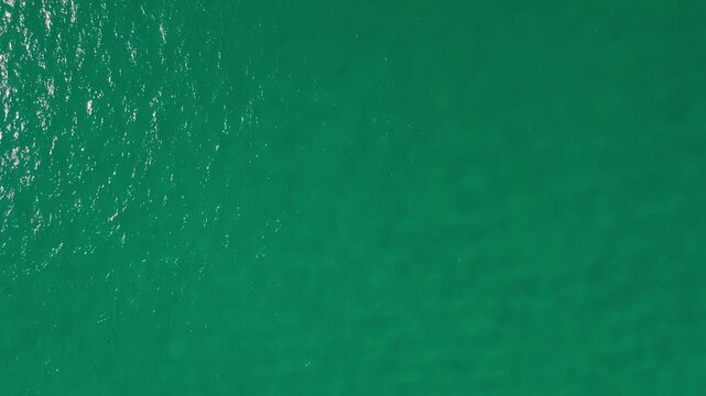 DRONE TOP-DOWN VIEW OF THE CALM BLUE WATER IN THE BEACH OF IXTAPA
