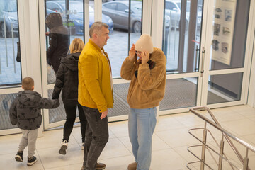 Obraz premium Visitors entering a building with a family stopping to talk in a lobby area during daytime