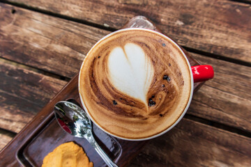 Top view a cup of coffee latte art on rustic wooden table