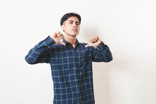 Confident young man pointing at himself with a proud, arrogant expression, showing self-importance in a studio setting.