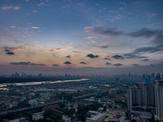 Obraz premium 13 December 2025 colourful sunset with fluffy white pink purple orange and blue skies over the city towers of BKK Bangkok Thai Thailand