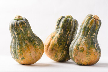 Ripe, yellow-green butternut squash after autumn harvest from an organic farm, on a white background. A healthy cooking ingredient