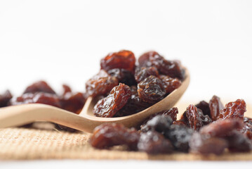 Dried dark raisins on a white background. A healthy snack