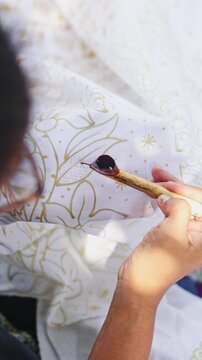 Indonesian artist painting traditional batik fabric