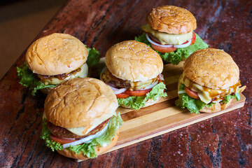 Assortment of Gourmet Cheeseburgers on Wooden Board – Fresh Homemade Fast Food Concept