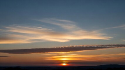 Obraz premium Vibrant Sunset Sky with Streaky Clouds and Golden Light.