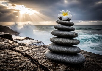 Perfectly Balanced Zen Stones with Plumeria Flower on Rocky Shore at Dramatic Sunset