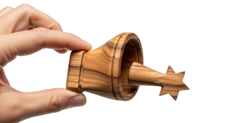 Hand holding a small wooden spinning top with star-shaped tip on white background