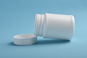 Opened blank plastic bottle medicine isolated on blue background.