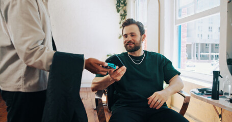 Happy man, hairdresser or customer paying with phone for payment, banking or pos machine in salon. Male people, barber or client with mobile smartphone for NFC tap or wireless transaction in parlor