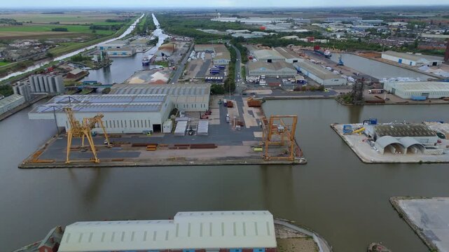 Aerial view above Goole harbour detailing busy maritime operations, mechanical lifting systems, cargo movement channels, and industrial storage sectors.