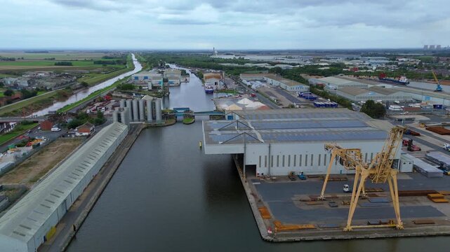 Wide drone panorama of Goole industrial port exposing cranes, berths, metal yards, service buildings, and core transport corridors supporting large-scale shipping.
