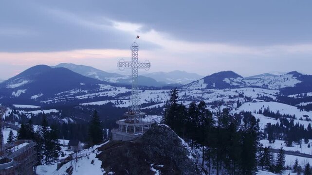 Aerial shot of a cross-shaped monument on a mountain. Tihuta Pass, Bistrita - Nasaud, Romania