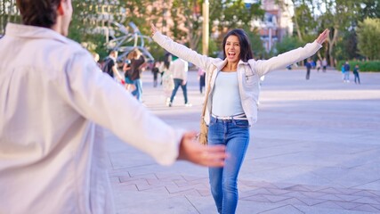 Happy couple reuniting for an inclusive embrace outdoors