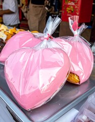 Heart-shaped confections, wrapped, on metal surface