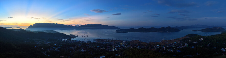 Wide high angle view of Coron Town harbor and islands during golden sunrise on Busuanga Island, Palawan, Philippines