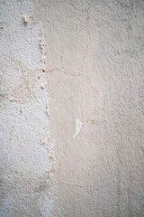 Textured peeling wall with subtle cracks and a mix of beige tones.