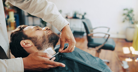 Hairdresser, barber and man with shave in salon for grooming, haircut and trim for beard. Hair service, chair and people with tools, razor and cut for styling, wellness and treatment in barbershop
