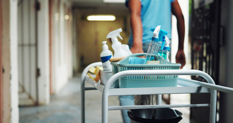 Hands, person and cart with supplies for cleaning, corridor maintenance and workplace hygiene. Volunteer, trolley and equipment for hallway cleanliness, chemical detergent and sanitation of facility