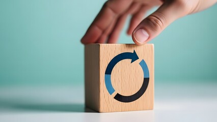 Hand interacting with a wooden block featuring a blue circular arrow symbol