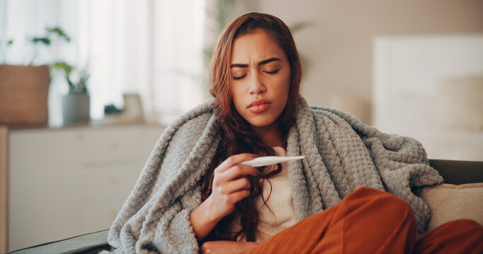 Fototapeta Sick, woman and thermometer in home for virus infection, influenza or allergy on living room sofa. Girl, winter and fever with high temperature in lounge, cold or medical health problem with blanket